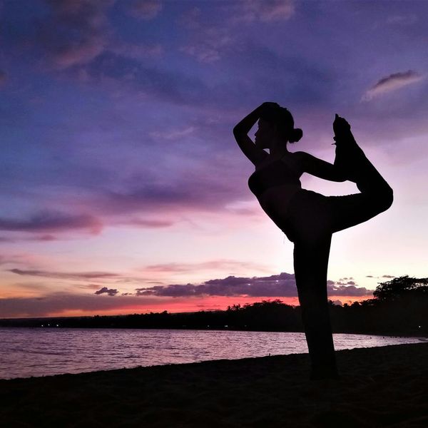 Silhouette of a person in a graceful yoga pose at sunset.